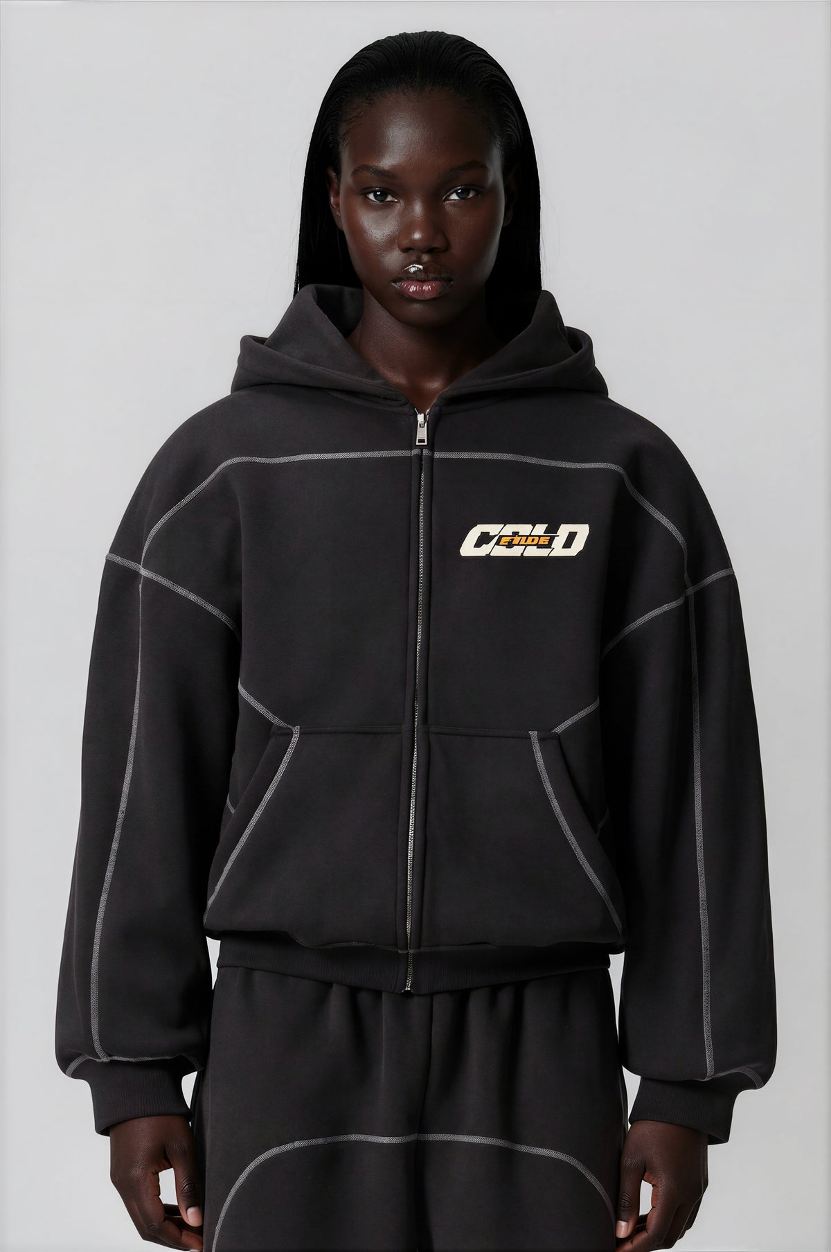 Model in a contrast-stitched zip hoodie